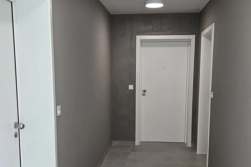 Couloir peint en gris avec portes et plafond blancs